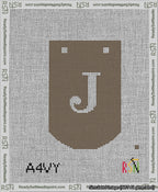 A taped needlepoint canvas with the design: Banner 13 mesh count Curved J White on Brown.