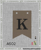 A taped needlepoint canvas with the design: Banner 13 mesh count Forked K Black on Brown.