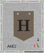 A taped needlepoint canvas with the design: Banner 13 mesh count Pointed H Black on Brown.