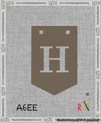 A taped needlepoint canvas with the design: Banner 13 mesh count Pointed H White on Brown.