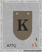 A taped needlepoint canvas with the design: Banner 13 mesh count Rounded K Black on Brown.