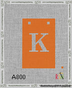 A taped needlepoint canvas with the design: Banner 13 mesh count Squared K White on Orange.