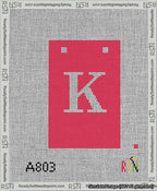 A taped needlepoint canvas with the design: Banner 13 mesh count Squared K White on Red.