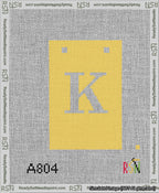 A taped needlepoint canvas with the design: Banner 13 mesh count Squared K White on Yellow.