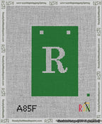A taped needlepoint canvas with the design: Banner 13 mesh count Squared R White on Green.