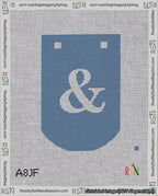 A taped needlepoint canvas with the design: Banner 18 mesh count Curved Ampersand White on Blue.