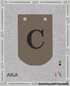 A taped needlepoint canvas with the design: Banner 18 mesh count Curved C Black on Brown.