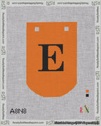 A taped needlepoint canvas with the design: Banner 18 mesh count Curved E Black on Orange.