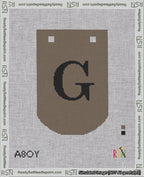 A taped needlepoint canvas with the design: Banner 18 mesh count Curved G Black on Brown.