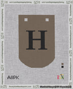 A taped needlepoint canvas with the design: Banner 18 mesh count Curved H Black on Brown.