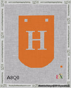 A taped needlepoint canvas with the design: Banner 18 mesh count Curved H White on Orange.