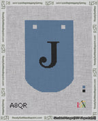 A taped needlepoint canvas with the design: Banner 18 mesh count Curved J Black on Blue.