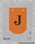 A taped needlepoint canvas with the design: Banner 18 mesh count Curved J Black on Orange.