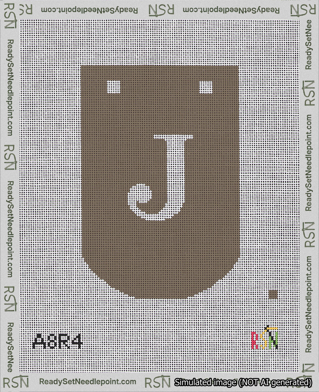 A taped needlepoint canvas with the design: Banner 18 mesh count Curved J White on Brown.