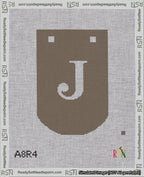 A taped needlepoint canvas with the design: Banner 18 mesh count Curved J White on Brown.