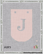 A taped needlepoint canvas with the design: Banner 18 mesh count Curved J White on Pink.