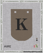 A taped needlepoint canvas with the design: Banner 18 mesh count Curved K Black on Brown.