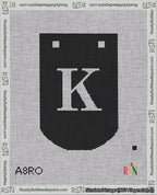 A taped needlepoint canvas with the design: Banner 18 mesh count Curved K White on Black.