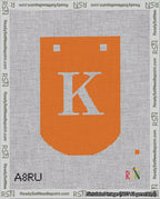 A taped needlepoint canvas with the design: Banner 18 mesh count Curved K White on Orange.