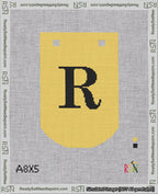 A taped needlepoint canvas with the design: Banner 18 mesh count Curved R Black on Yellow.