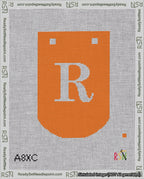 A taped needlepoint canvas with the design: Banner 18 mesh count Curved R White on Orange.