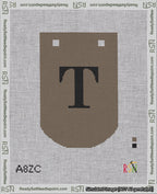 A taped needlepoint canvas with the design: Banner 18 mesh count Curved T Black on Brown.