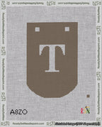 A taped needlepoint canvas with the design: Banner 18 mesh count Curved T White on Brown.