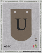 A taped needlepoint canvas with the design: Banner 18 mesh count Curved U Black on Brown.