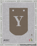 A taped needlepoint canvas with the design: Banner 18 mesh count Curved Y White on Brown.