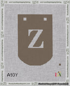 A taped needlepoint canvas with the design: Banner 18 mesh count Curved Z White on Brown.