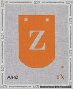 A taped needlepoint canvas with the design: Banner 18 mesh count Curved Z White on Orange.