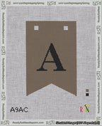 A taped needlepoint canvas with the design: Banner 18 mesh count Forked A Black on Brown.