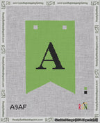 A taped needlepoint canvas with the design: Banner 18 mesh count Forked A Black on Light Green.
