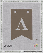 A taped needlepoint canvas with the design: Banner 18 mesh count Forked A White on Brown.