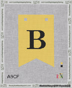 A taped needlepoint canvas with the design: Banner 18 mesh count Forked B Black on Yellow.