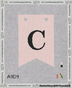A taped needlepoint canvas with the design: Banner 18 mesh count Forked C Black on Pink.