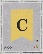 A taped needlepoint canvas with the design: Banner 18 mesh count Forked C Black on Yellow.
