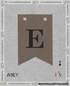 A taped needlepoint canvas with the design: Banner 18 mesh count Forked E Black on Brown.