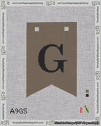 A taped needlepoint canvas with the design: Banner 18 mesh count Forked G Black on Brown.