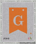 A taped needlepoint canvas with the design: Banner 18 mesh count Forked G White on Orange.