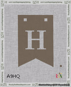 A taped needlepoint canvas with the design: Banner 18 mesh count Forked H White on Brown.