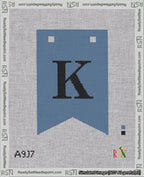 A taped needlepoint canvas with the design: Banner 18 mesh count Forked K Black on Blue.