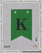 A taped needlepoint canvas with the design: Banner 18 mesh count Forked K Black on Green.