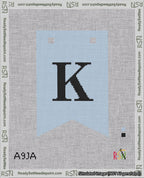 A taped needlepoint canvas with the design: Banner 18 mesh count Forked K Black on Light Blue.