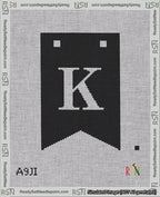 A taped needlepoint canvas with the design: Banner 18 mesh count Forked K White on Black.