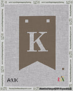 A taped needlepoint canvas with the design: Banner 18 mesh count Forked K White on Brown.