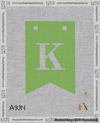 A taped needlepoint canvas with the design: Banner 18 mesh count Forked K White on Light Green.