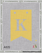 A taped needlepoint canvas with the design: Banner 18 mesh count Forked K White on Yellow.