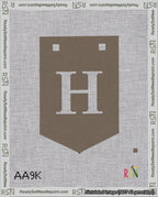 A taped needlepoint canvas with the design: Banner 18 mesh count Pointed H White on Brown.