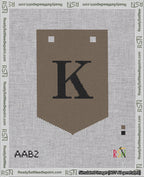 A taped needlepoint canvas with the design: Banner 18 mesh count Pointed K Black on Brown.